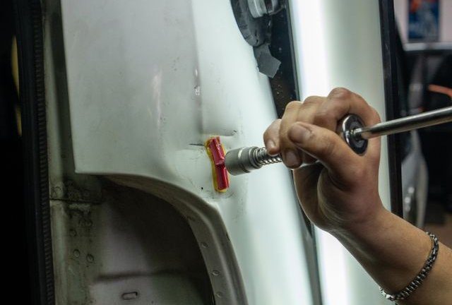 Técnico reparando una abolladura en la carrocería